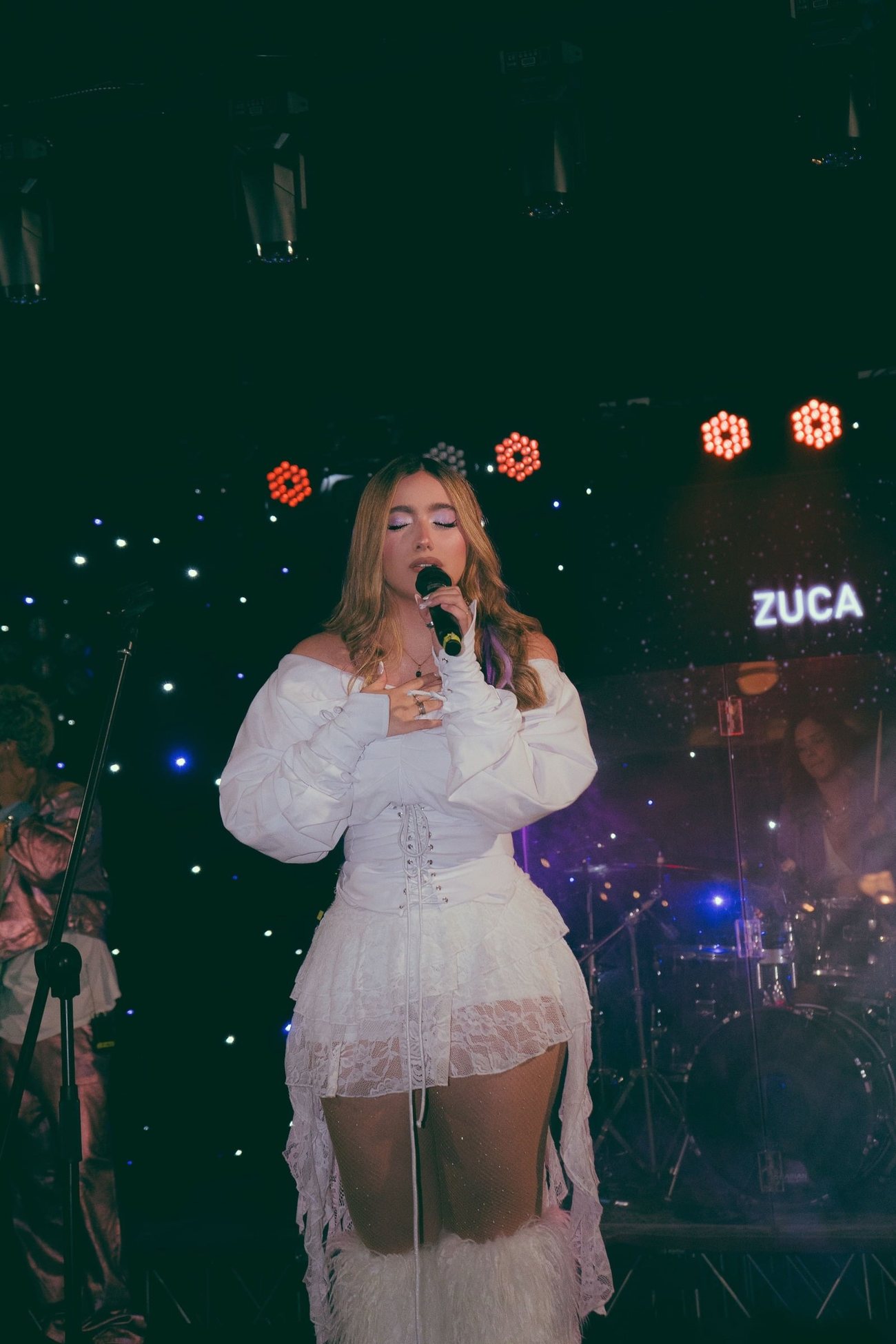 ZUCA cantando con vestido blanco